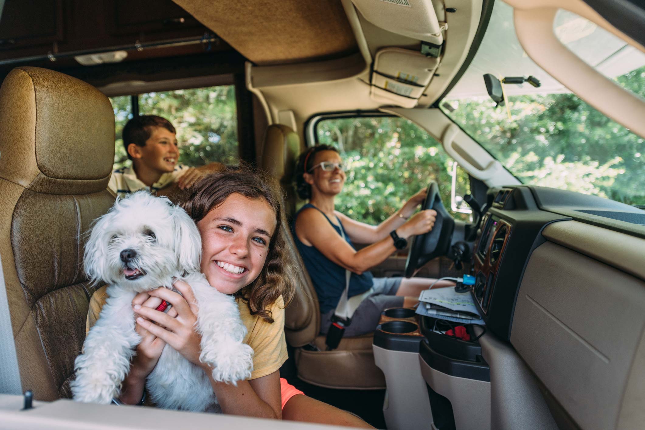 Familie med hund kører på campingferie i autocamper