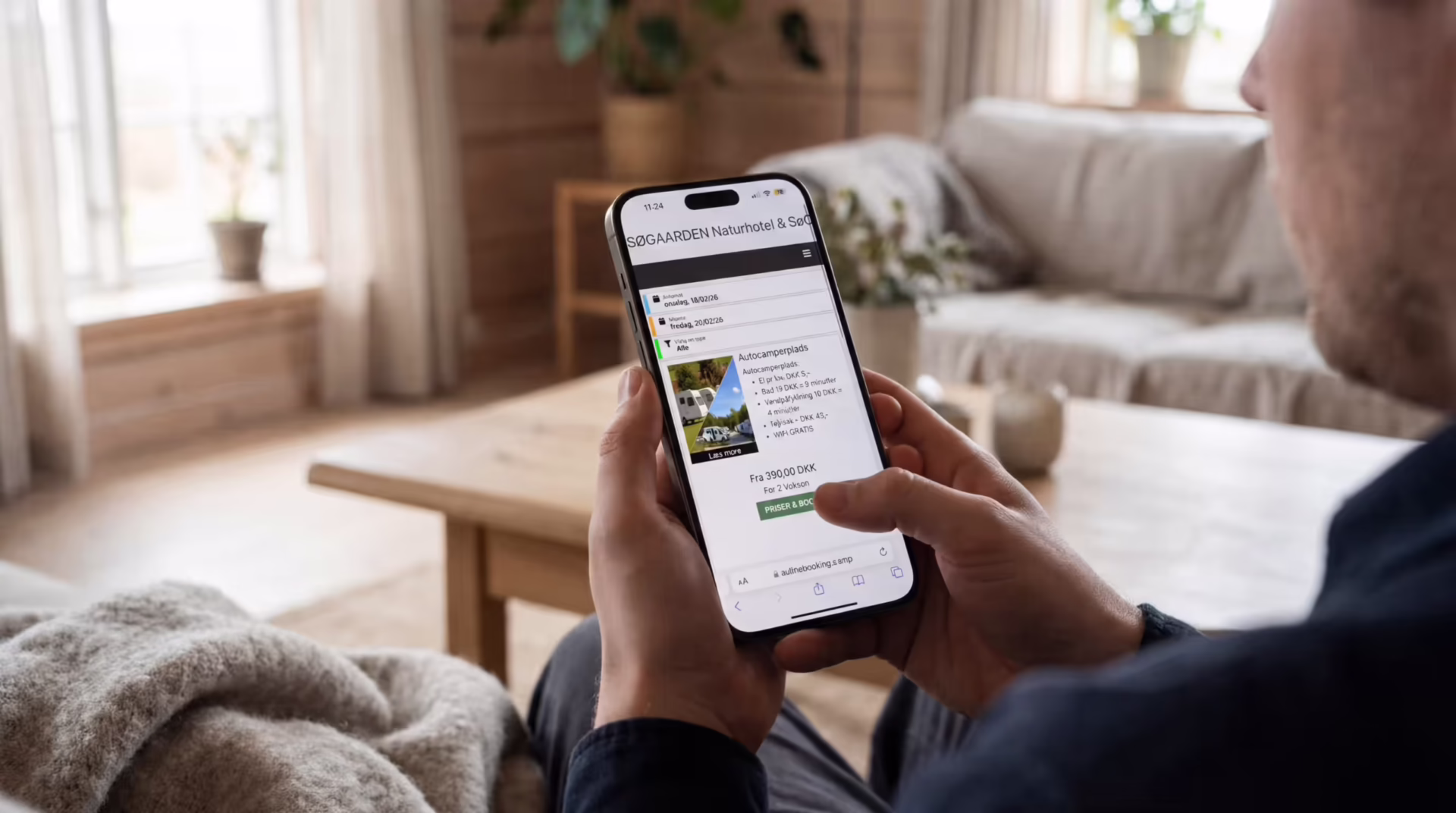 Mand bruger mobil med dansk booking system Mand bruger mobil med booking system til at vælge hytte på campingplads